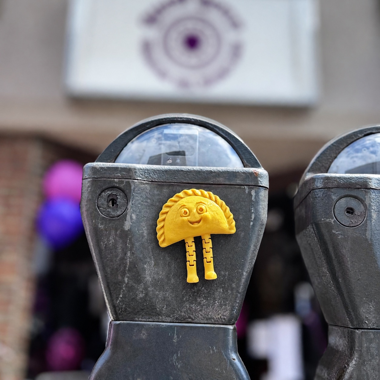 Yellow Pittsburgh Pierogi Magnet attached to a parking meter in Bellevue